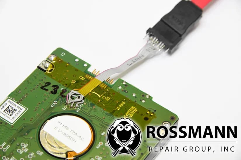 Shucked external drive PCB with thin wires soldered from the internal SATA test pads up to a SATA cable, bypassing the failing USB bridge board for imaging