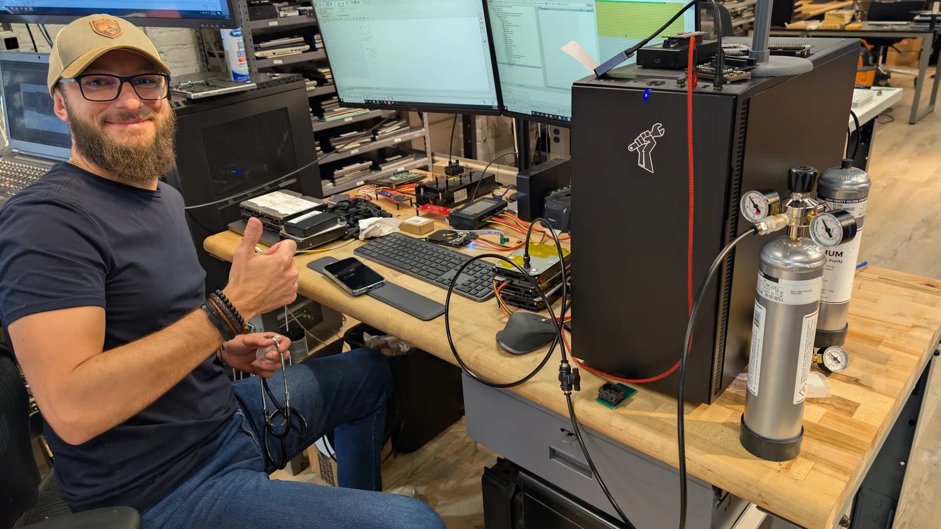 Chris at the helium drive recovery workstation with helium tank and PC-3000 equipment at Rossmann Repair Group Austin lab