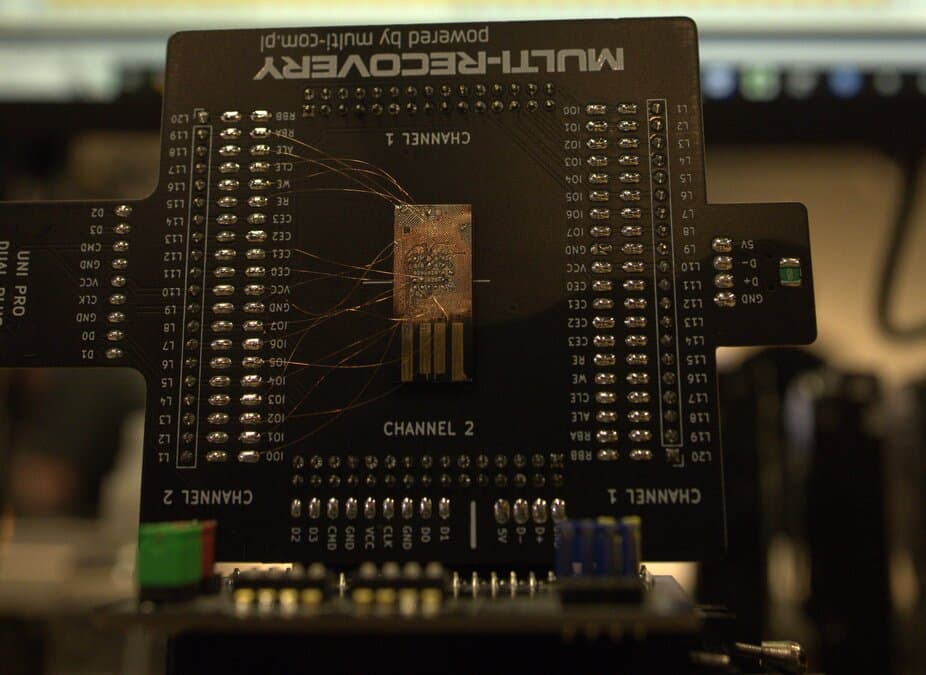 MicroSD card under microscope showing exposed traces